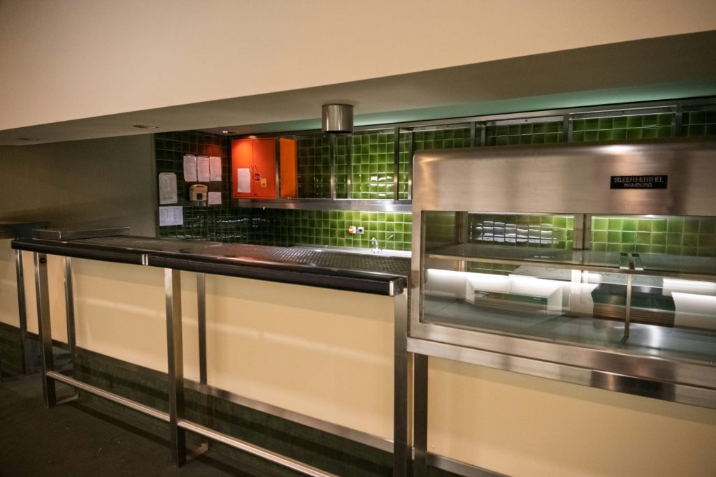A modern cafeteria serving counter with stainless steel equipment.